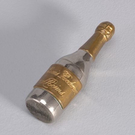 A champagne bottle with a gold-foiled neck, lying on its side.