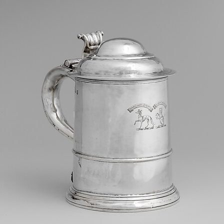 A plain silver tankard with a hinged lid and scroll handle.