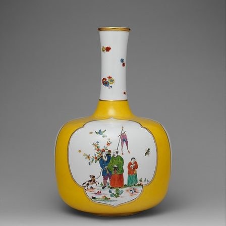 A porcelain vase with a painted reserve panel on a yellow ground.